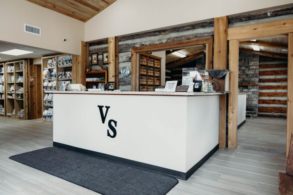 Architectural design for a one-story veterinary hospital featuring modern board and batten wood siding and custom red door entry.