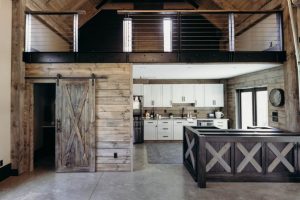 A rustic barn interior with a modern kitchen and open floor plan.