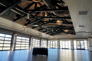 A large, empty room with a high ceiling and many windows.